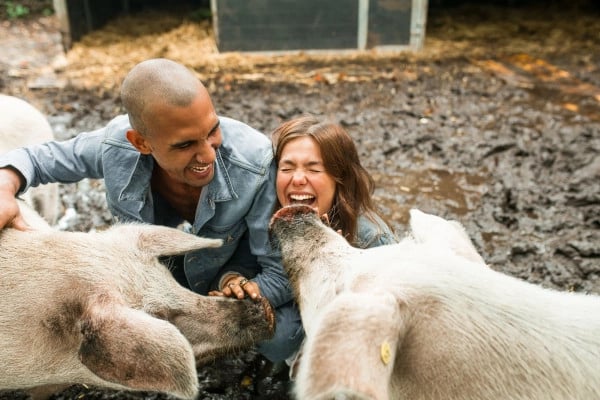 Abby en Noah lachen in de modder met 2 varkens